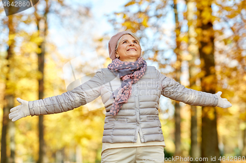 Image of happy senior woman enjoying beautiful autumn