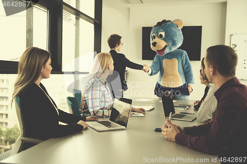 Image of boss dresed as bear having fun with business people in trendy of