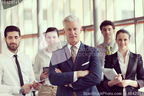Image of portrait of senior businessman as leader  with group of people i