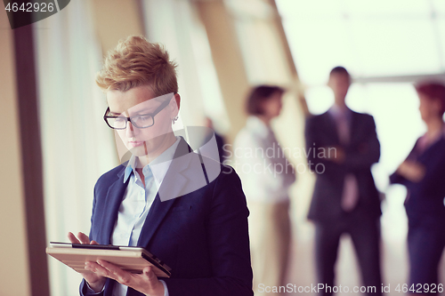 Image of business woman  at office with tablet  in front  as team leader