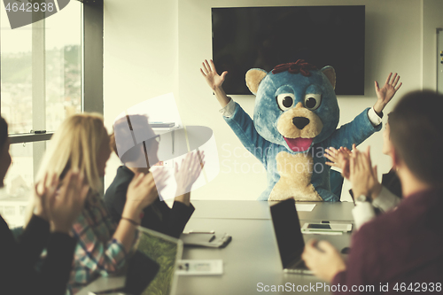 Image of boss dresed as bear having fun with business people in trendy of