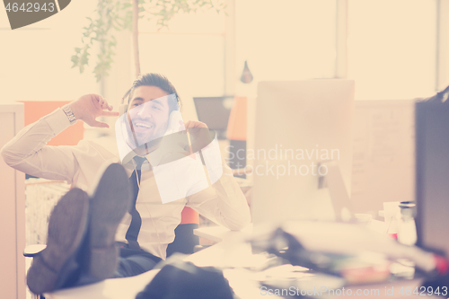 Image of relaxed young business man at office