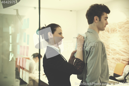 Image of young couple signing contract documents on partners back