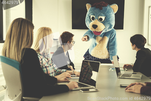 Image of boss dresed as bear having fun with business people in trendy of