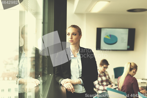 Image of portrait of young business woman at office with team on meeting 