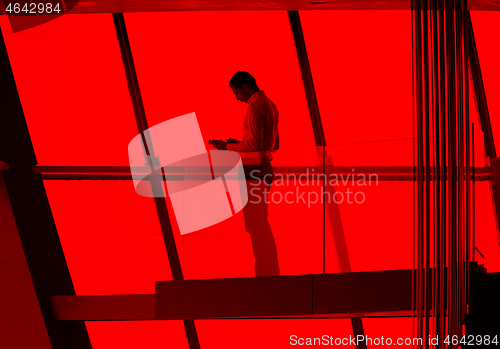 Image of young successful business man in penthouse apartment working on 