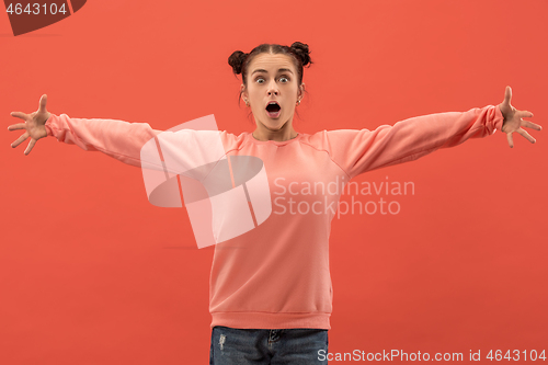 Image of Beautiful woman looking suprised isolated on coral