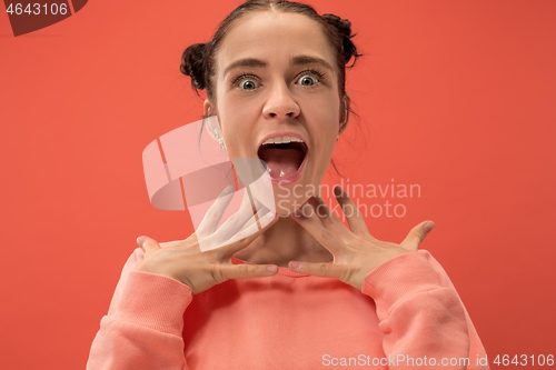 Image of Beautiful woman looking suprised isolated on coral