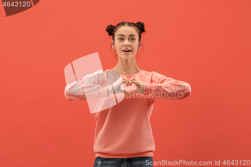 Image of Portrait of attractive cute girl with bright makeup with love isolated over coral background