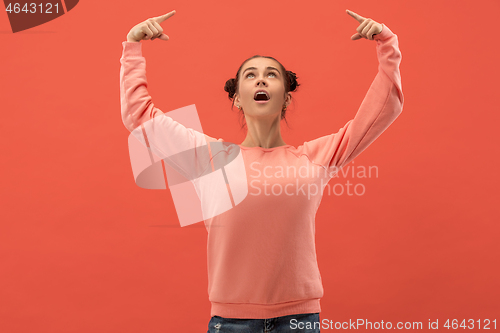 Image of The happy woman standing and smiling against coral background.