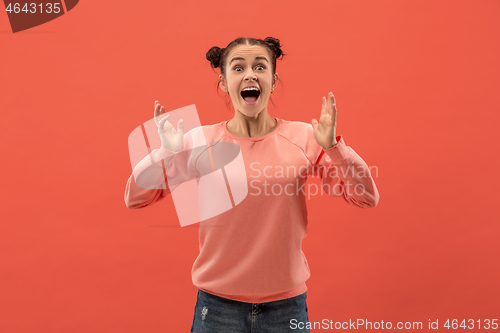 Image of Beautiful woman looking suprised isolated on coral