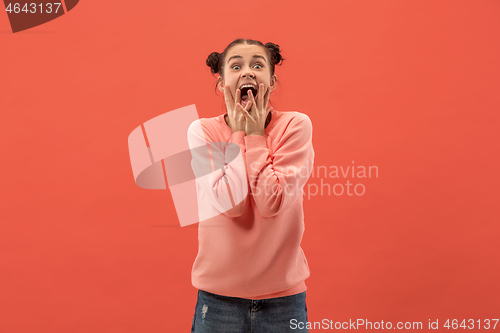 Image of Beautiful woman looking suprised isolated on coral