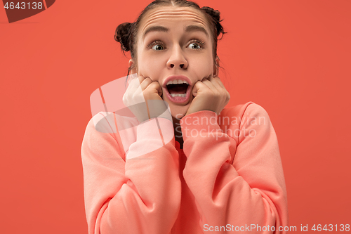 Image of Beautiful woman looking suprised isolated on coral