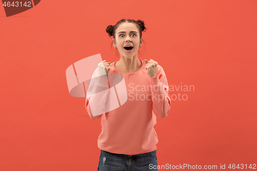 Image of Beautiful woman looking suprised isolated on coral