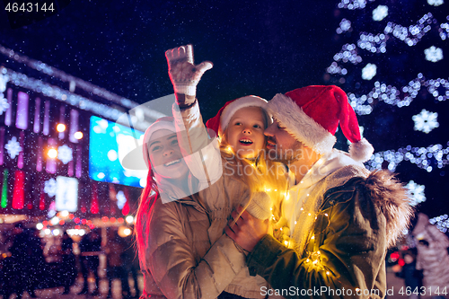 Image of family, christmas, holidays, season and people concept - happy family over city background and snow