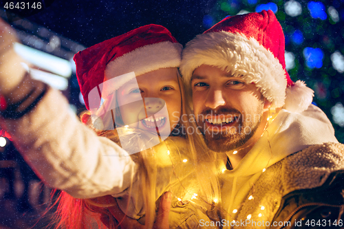 Image of family, christmas, holidays, season and people concept - happy family over city background and snow