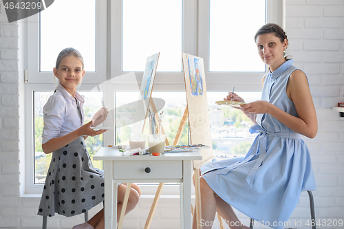 Image of Girl and girl sit by the window and draw a picture, looked into the frame