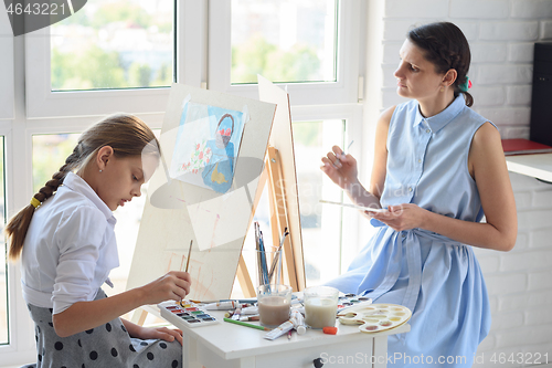 Image of Mom and blackboard are fond of painting and draw sitting by the window on a weekend