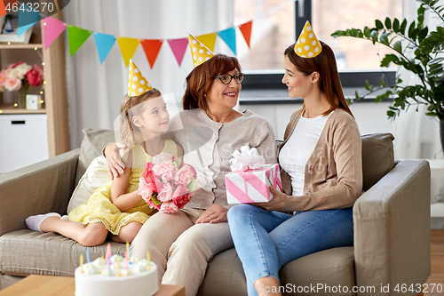 Image of mother with gift greeting grandmother on birthday