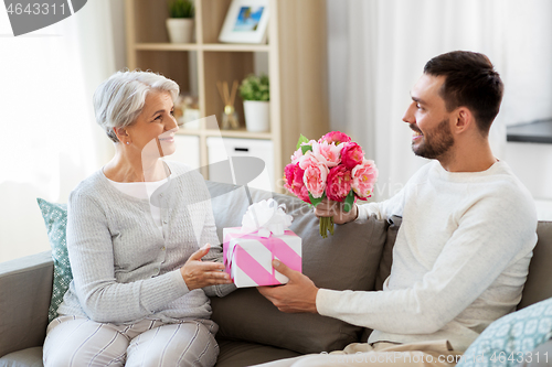 Image of son giving present and flowers to senior mother