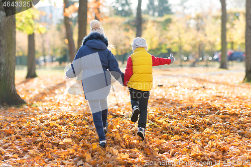 Image of happy children running at autumn park