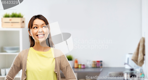 Image of happy asian woman looking up at kitchen