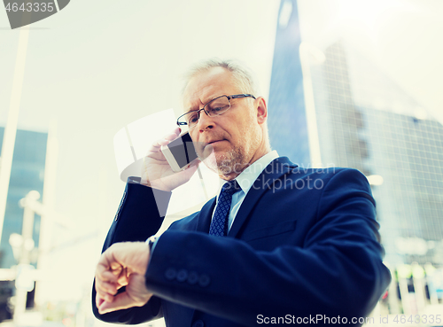 Image of senior businessman calling on smartphone in city