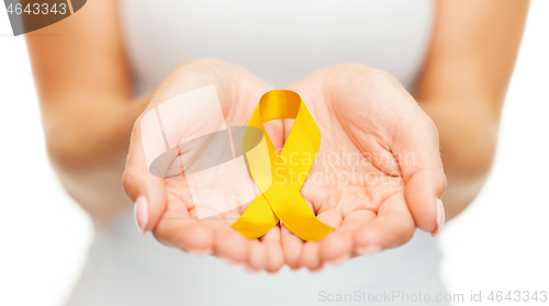 Image of hands holding yellow gold cancer awareness ribbon