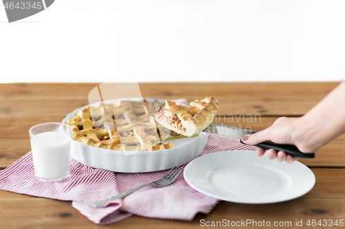 Image of close up of hand with piece of apple pie on knife
