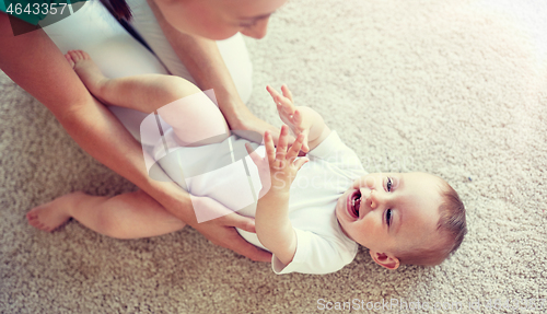 Image of happy mother playing with baby at home