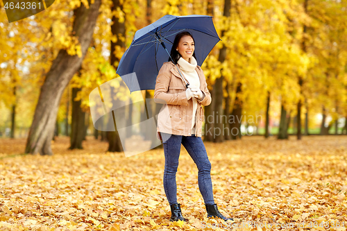 Image of happy woman with umbrella in autumn park