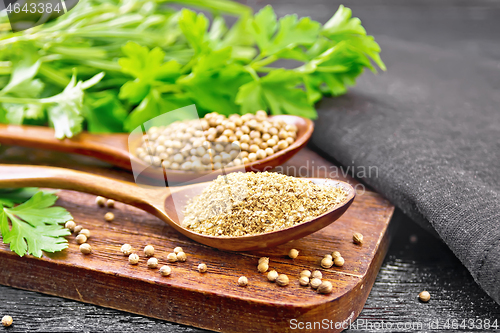 Image of Coriander ground and seeds in two spoons on black board