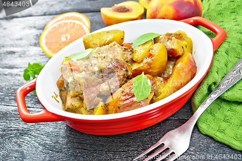 Image of Turkey with peaches in pan on dark board