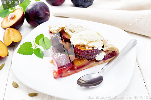 Image of Galeta with plums in plate on wooden table