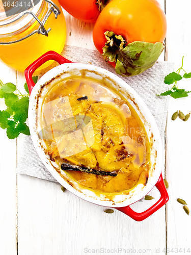 Image of Persimmons baked with honey in pan on board top