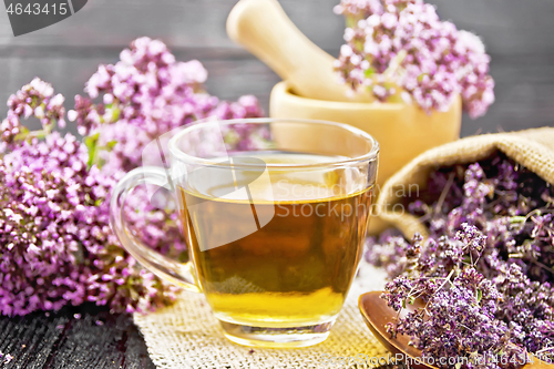 Image of Tea of oregano in cup with mortar on table