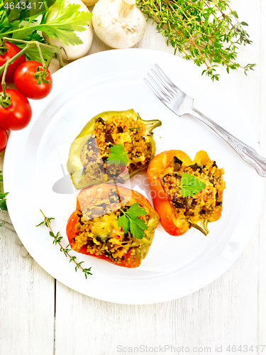 Image of Pepper stuffed with mushrooms and couscous in plate on board top