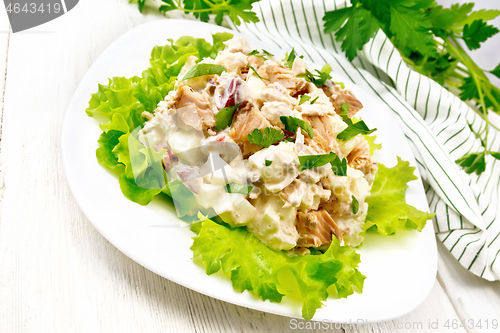 Image of Salad of salmon and cucumber in plate on board