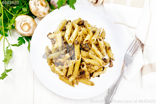 Image of Pasta with mushrooms in white plate on board top