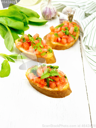 Image of Bruschetta with tomato and spinach on light table