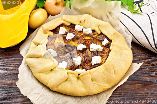 Image of Pie with pumpkin and onions on dark board