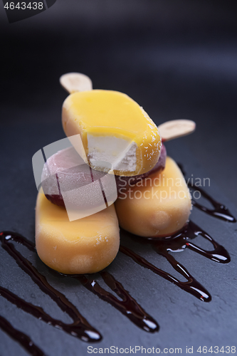 Image of Stack of ice cream stick placed on a black stone background