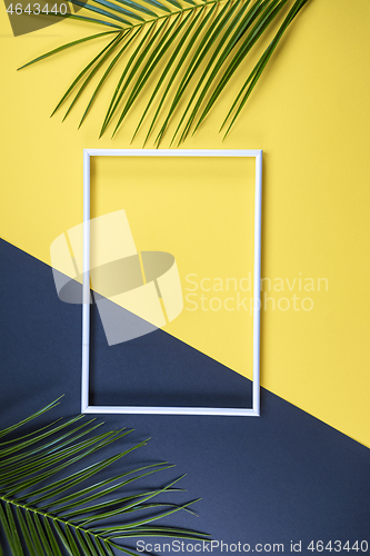 Image of Summer composition with photo frame and green leaves on yellow b