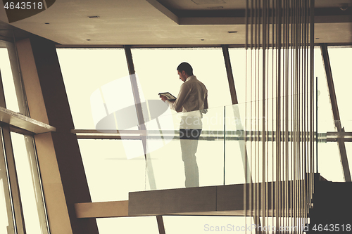 Image of young successful business man in penthouse apartment working on 