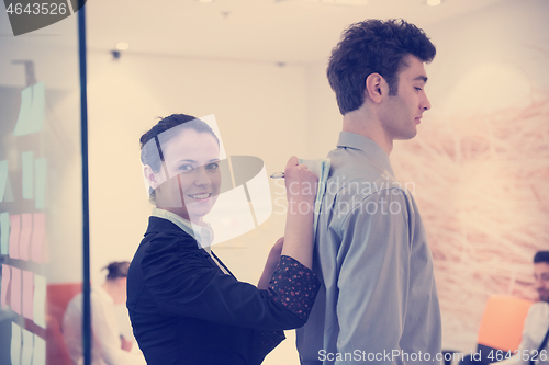 Image of young couple signing contract documents on partners back