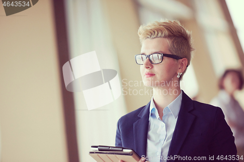 Image of business woman  at office with tablet  in front  as team leader