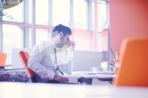 Image of frustrated young business man at work