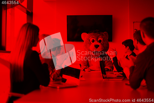 Image of boss dresed as bear having fun with business people in trendy of