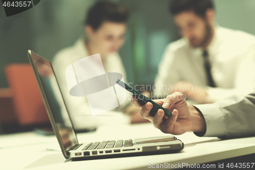 Image of close up of  businessman hands  using smart phone on meeting