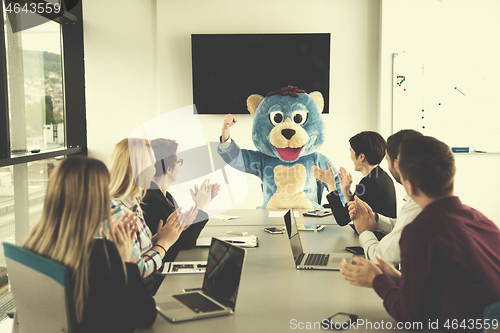 Image of boss dresed as bear having fun with business people in trendy of